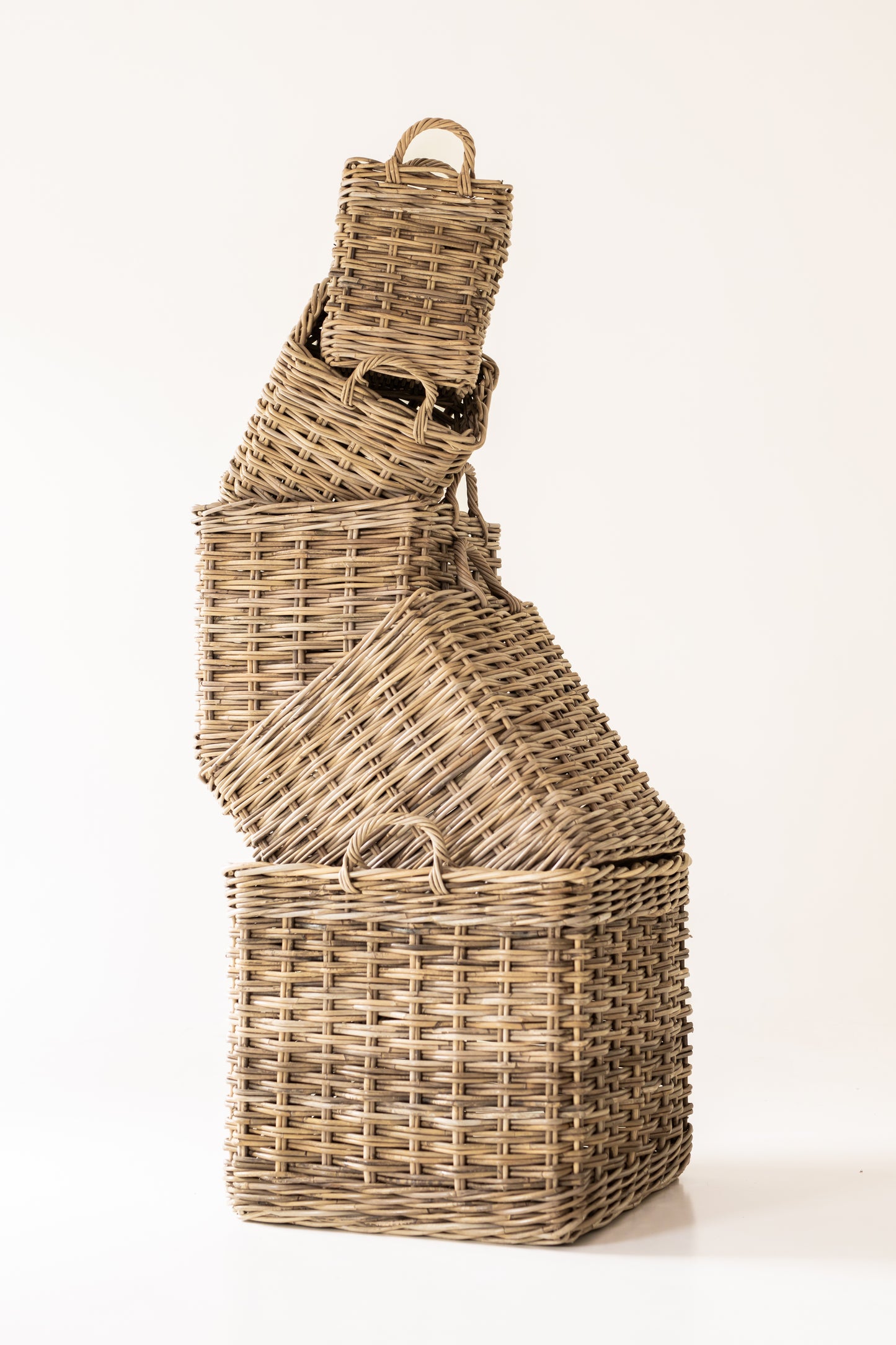 Stack of Rattan baskets of varying sizes on a white background
