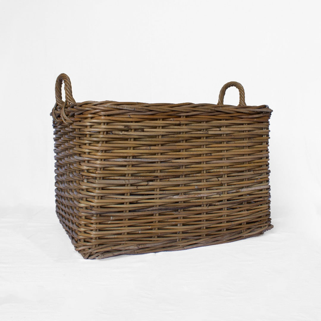 A rectangular rattan storage basket with handles, handwoven from natural materials, with a rustic brown color.