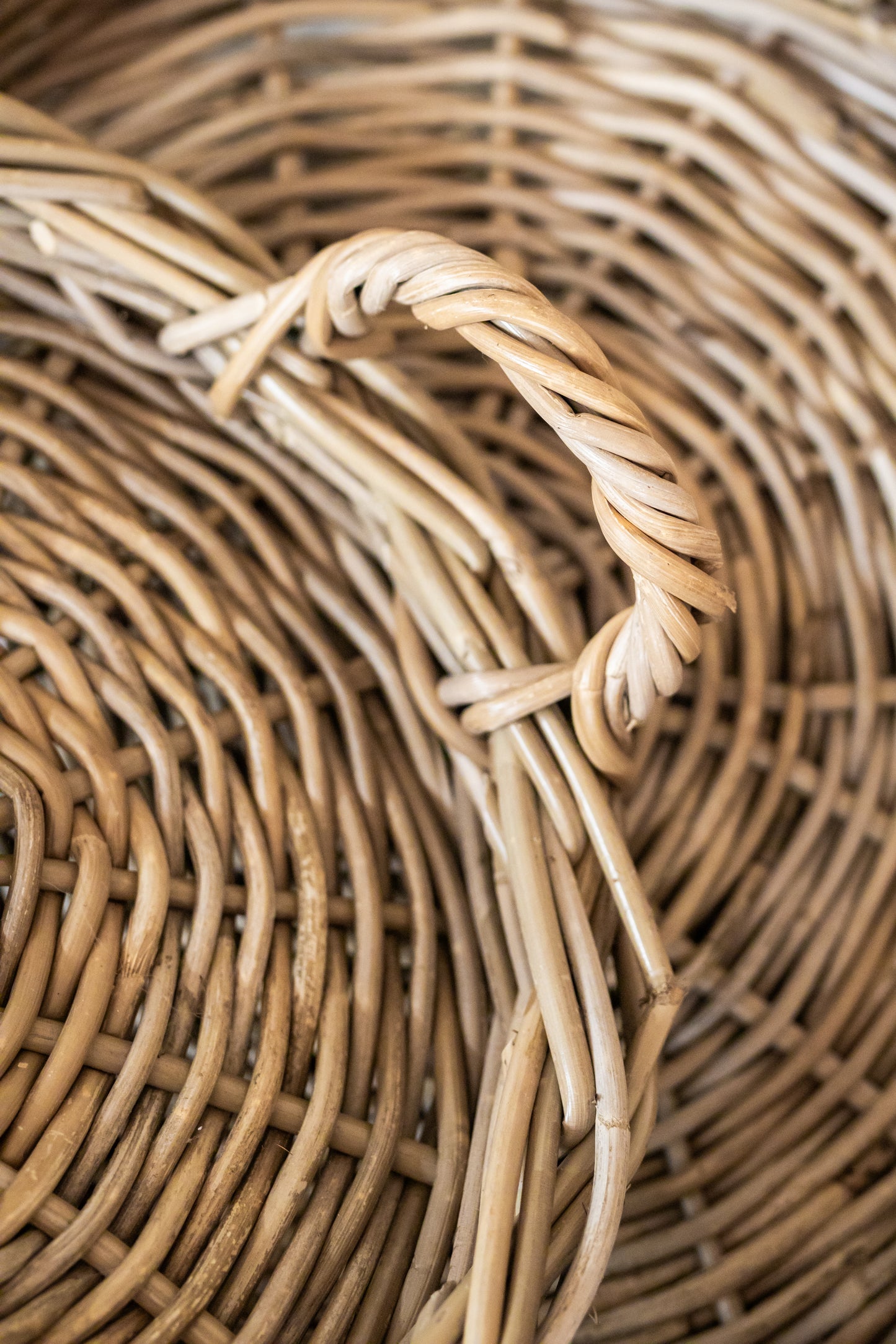 Close-up of a rattan tray with a twisted handle.