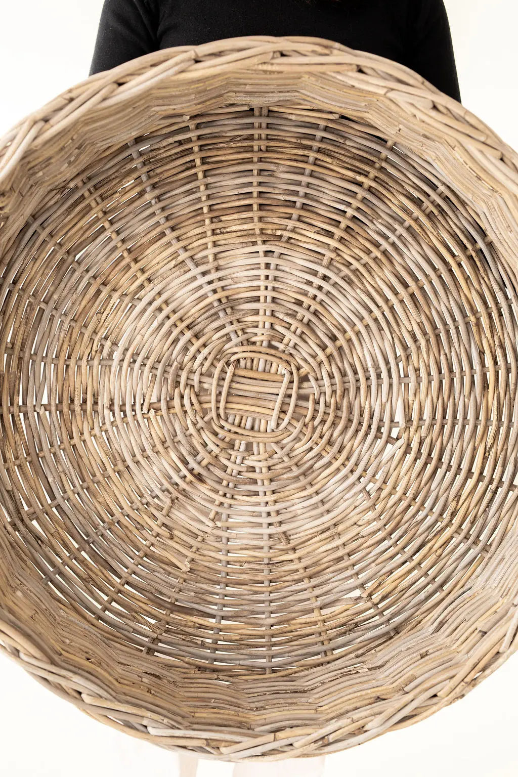 Close-up of a woven basket with concentric circles on a white background