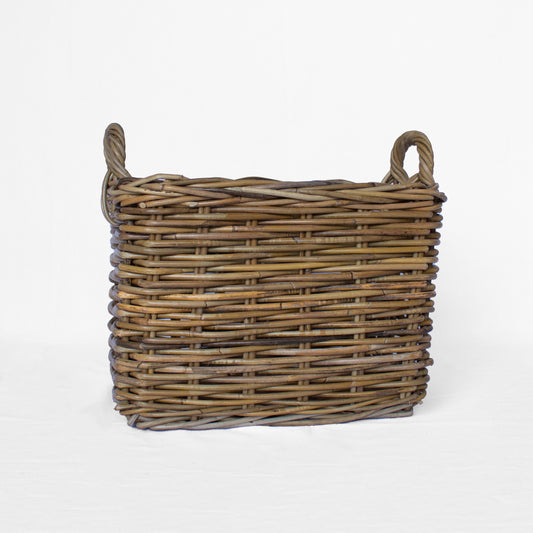 A rectangular rattan storage basket with handles, handwoven from natural materials, with a rustic brown color.